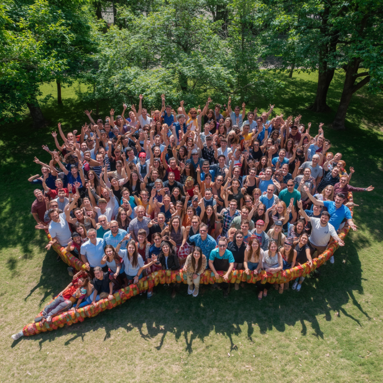 A large group of people standing in a speech bubble shape